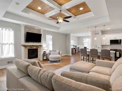 Living room with coffered ceiling, a wood ceiling with exposed beams, healthy amount of natural light, light wood-style floors, and recessed lighting