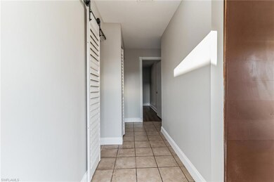 Hall with a barn door and light tile floors