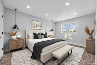 Bedroom with light wood finished floors and recessed lighting