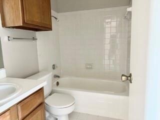 Full bathroom with toilet, vanity, and tiled showe