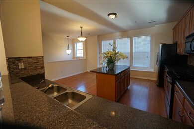 Kitchen with appliances with stainless steel finishes, dark countertops, dark wood finished floors, and brown cabinetry