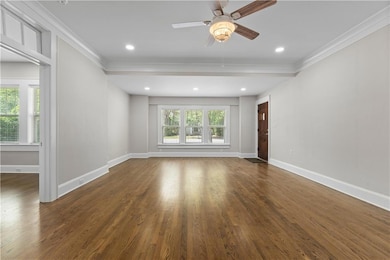 Empty room featuring ornamental molding, wood finished floors, ceiling fan, baseboards, and recessed lighting