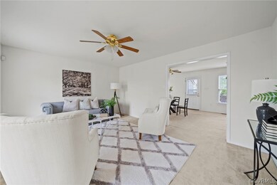 Living room featuring light carpet and ceiling fan