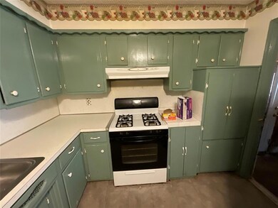 Kitchen featuring green cabinets, white range with