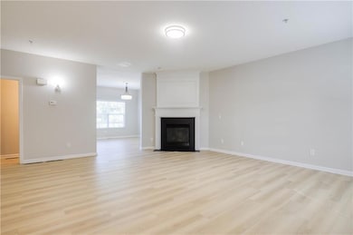 Unfurnished living room with light wood finished floors and a large fireplace