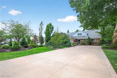 View of front of house with concrete driveway and a front yard