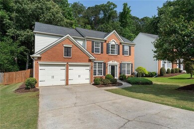 Colonial house with brick siding and concrete driveway