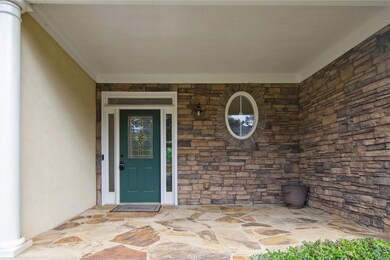 Doorway to property with stucco siding and stone s