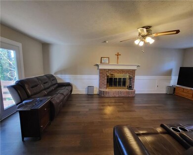 Living room featuring a textured ceiling, a firepl