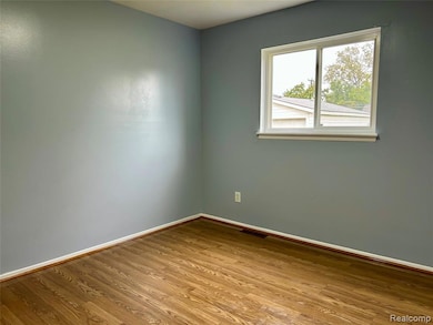 Unfurnished room with baseboards and wood finished floors