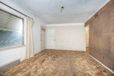 Spare room featuring brick wall