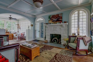 Living room boasts custom ceiling, old world light