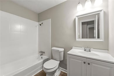 Full bathroom featuring shower / bath combination, vanity, and dark wood-style floors