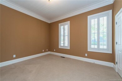 Bedroom 2 faces the front porch and has neutral ca