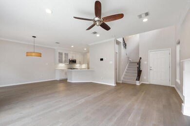 Unfurnished living room featuring stairway, ornamental molding, light wood finished floors, a ceiling fan, and recessed lighting