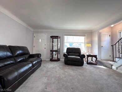 Living room featuring crown molding and light colored carpet