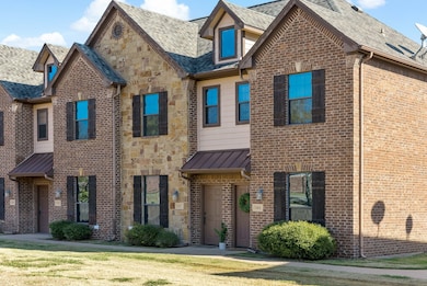 View of front of house with stone siding, brick siding, a front lawn, and a metal roof