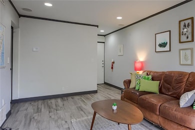 Living room featuring ornamental molding, light w