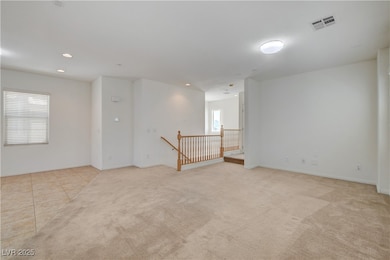 Dining room with light colored carpet, recessed li