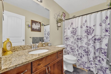 Full bath with a textured ceiling, vanity, and a shower with curtain