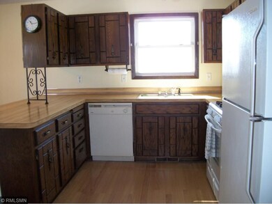 Kitchen has ample cupboards and wood flooring.