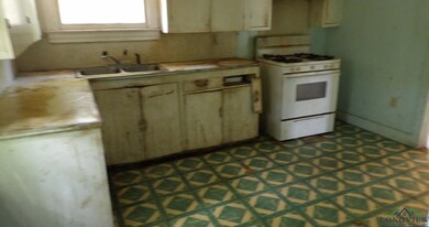 Kitchen featuring white gas stove and a sink