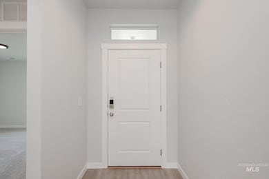 Entryway featuring baseboards and wood finished floors