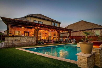Pool at dusk with a bar, a patio area, and a lawn