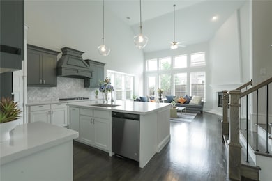 Kitchen with tasteful backsplash, stainless steel dishwasher, custom range hood, dark hardwood / wood-style flooring, and high vaulted ceiling
