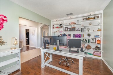 Office space featuring a textured ceiling, dark wo