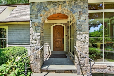 A Connecticut stone arch entrance with a Knotty Alder door welcomes you into the exceptional home.