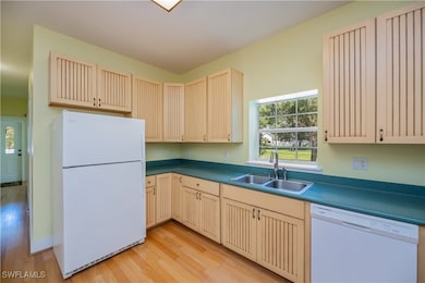 Kitchen featuring white appliances, cream cabinetr