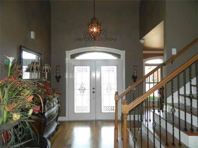 Entry Foyer: Inviting hardwood entry Foyer with Vaulted Ceiling & Double  leaded glass entry doors with eyebrow transom above, opens to the Dining Room and the Greatroom  