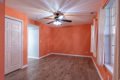Unfurnished room featuring dark wood-type flooring, ceiling fan, and a textured ceiling
