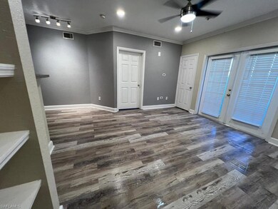Empty room featuring ceiling fan, wood finished floors, crown molding, baseboards, and french doors