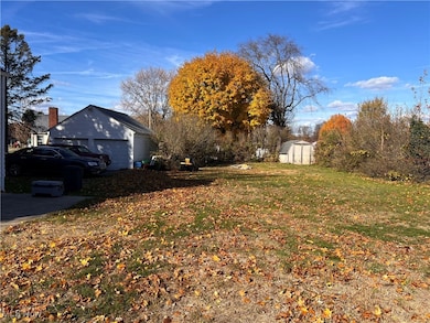 View of back yard with extra lot and 2 car garage.