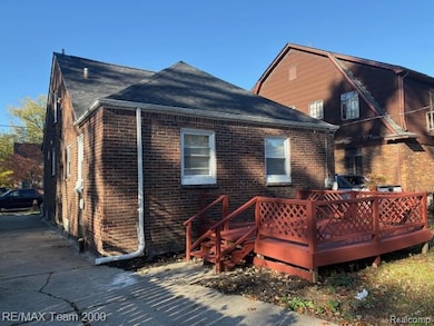 Back of house with brick siding and a shingled roof