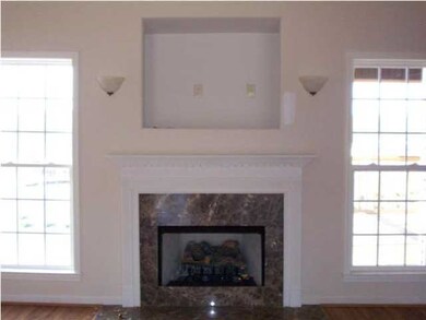 Fireplace with entertainment nook above and sconce