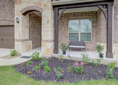 Entrance to property featuring brick siding, a ga