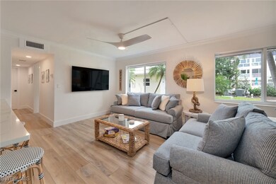 Living area with light wood-style flooring, crown molding, and a ceiling fan
