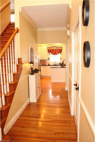 The sunny foyer with shining hardwood floors welco