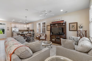 Living area featuring visible vents, ceiling fan, 