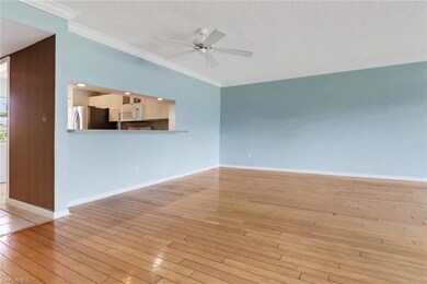 Spare room with ornamental molding, ceiling fan, light wood-type flooring, and a textured ceiling