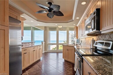 Kitchen featuring tasteful backsplash, stainless steel appliances, ceiling fan, a tray ceiling, and light wood cabinets