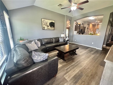 Living room featuring arched walkways, a ceiling f