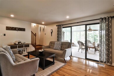 Spacious living room offers staircase to 2nd floor, beautiful wood floors, recessed lighting and also opens to the three season room located off the back of the home