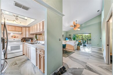 Kitchen featuring light brown cabinetry, white app