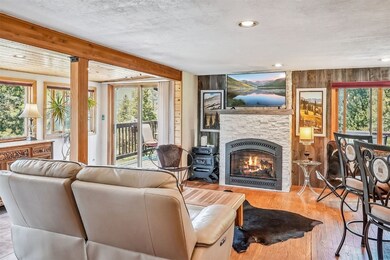 Living room with a stone fireplace, wooden walls,