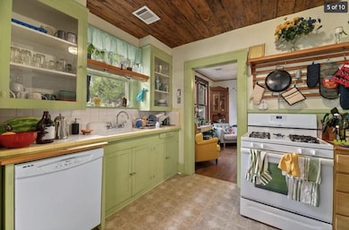 Kitchen featuring visible vents, a sink, white ap