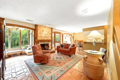 Living area with a textured ceiling and a stone f
